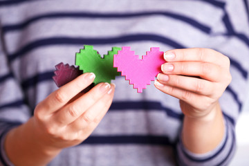 Closeup of plastic puzzle hearts in female hands