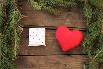 Red heart, fir tree and polka dot packed gift on wooden table - copy space - love concept