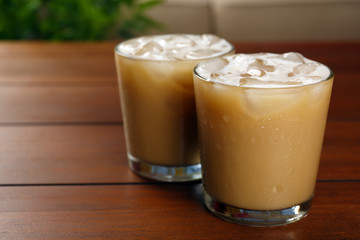 Cups of ice coffee on wooden table