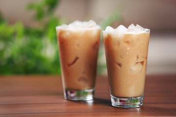 Cups of ice coffee on light blurred background