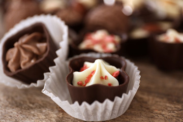 Chocolate candies on wooden background, close up