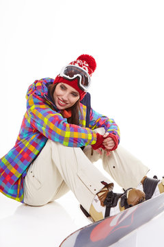 Young woman sitting on floor with snowboard