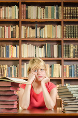 Worried female student in library with elbows on the table