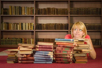 Female student laying on the books at library