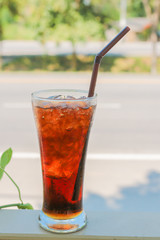 Lemon tea with ice in glass on nature background