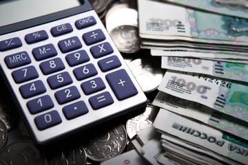 money in the form of banknotes and coins with calculator