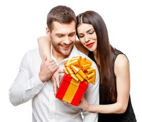 Young beautiful couple with present isolated on white