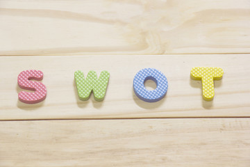  "SWOT" Concept Colorful word on wooden background.