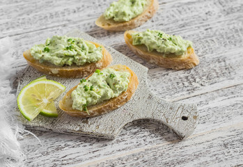 Toast with avocado and cream cheese on a white board. Healthy food. Delicious breakfast or snack