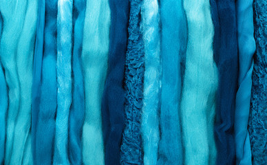 Turquoise wool of different colors and textures. Background made of wool felting in the form of lines..