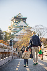 Father and his son walking on pathway to Osaka Castle