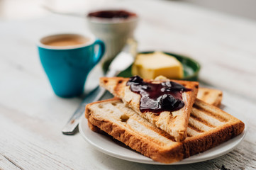 Breakfast with coffee, toasts, butter and jam