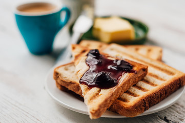 Breakfast with coffee, toasts, butter and jam