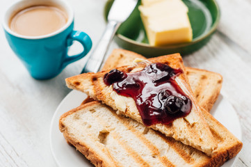 Breakfast with coffee, toasts, butter and jam