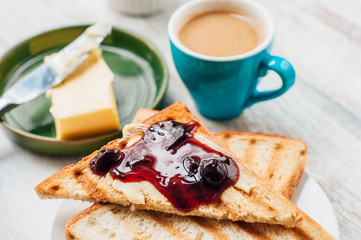 Breakfast with coffee, toasts, butter and jam