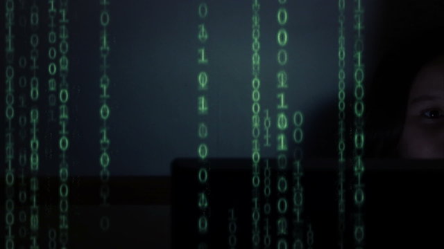 Young girl looking at screen with streaming binary code overlay

