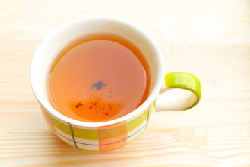 Cup of tea on bright wooden background
