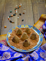 Vegan Homemade Candies in cocoa powder on Ethnic background.