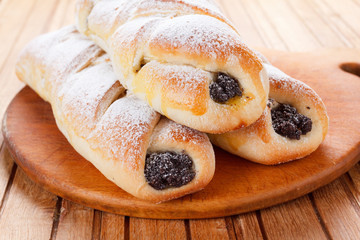Homemade pastries with poppy seeds on a wooden background
