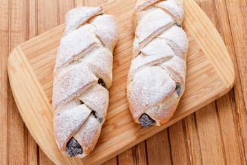 Homemade pastries with poppy seeds on a wooden background