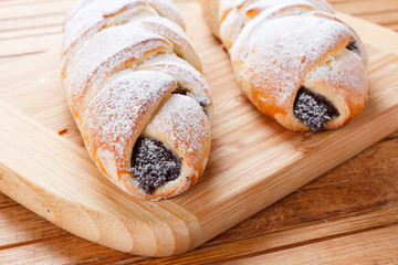 Homemade pastries with poppy seeds on a wooden background