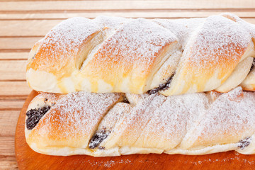 Homemade pastries with poppy seeds on a wooden background