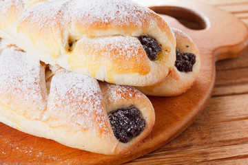 Homemade pastries with poppy seeds on a wooden background