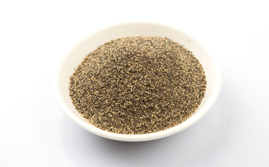 Black pepper powder in white bowl over white background
