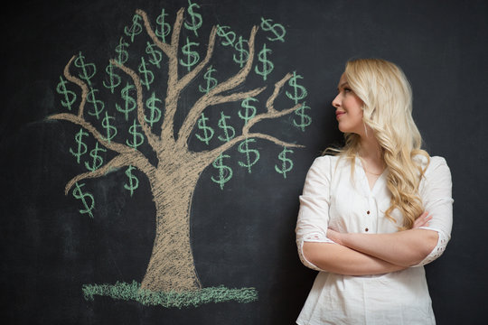 Happy blonde Business woman in front of chalk money tree drawing