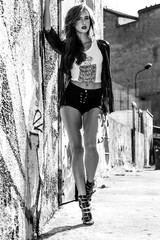 Fashionable woman portrait standing by urban wall black and white