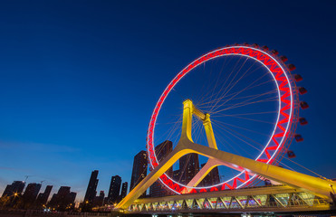 Night scene cityscape of Tianjin ferris wheel,Tianjin eye with  blue background. Tianjin eye is the most popular modern landmark in Tianjin city China.
