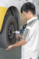 Mechanic repairing a car wheel in a garage