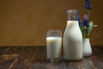 Milk bottle and milk glass put on wooden table.