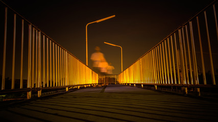 Footbridge with light reflection and motion blur of man walking