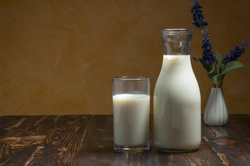 Milk bottle and milk glass put on wooden table.