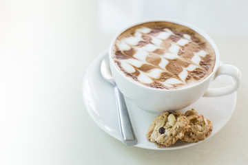 A cup of coffee in a white cup on mable table