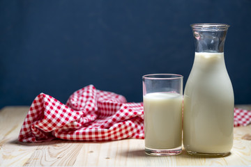 Milk bottle and milk glass put on wooden table.
