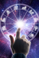 Obraz premium hand touching a zodiac chart with all astrology signs