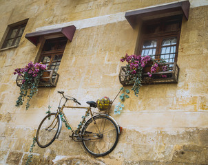 Decorated wall with suspended bike from a window of classic old building 