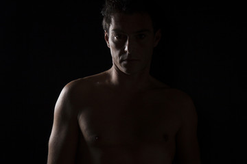 Fototapeta premium Uomo affascinante a torso nudo. Ritratto Low key in studio