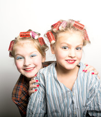 Two playful teenage girls in front of one eye laughing happily at the camera as they stand side by side