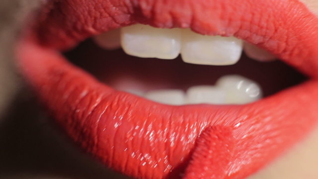 Girl paints lips. Close-up. Bright red