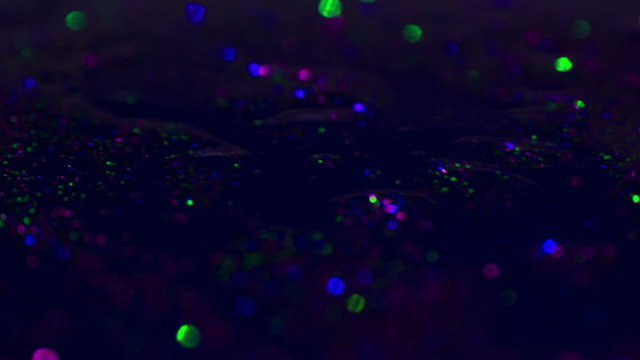 Sparkly Colorful Florescent Glitter Texture Background In Slow Motion