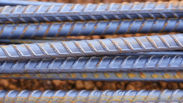 Panning shot of steel rods or bars used to reinforce concrete for construction