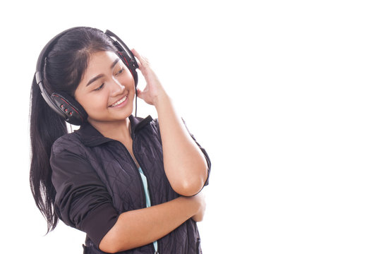 Portrait of young woman with headphones listening music. 