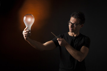 Ragazzo indica una lampadina accesa che tiene in mano: concetto di idea, ispirazione, creatività,...