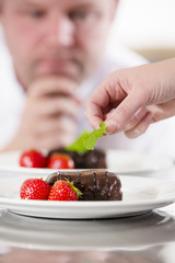 Obraz na płótnie Canvas Chef decorate dessert cake with strawberry