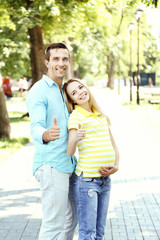 Fototapeta premium Young pregnant woman with husband outdoors