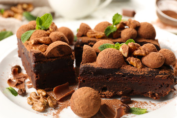 A piece of chocolate cake with walnut and mint on the table, close-up