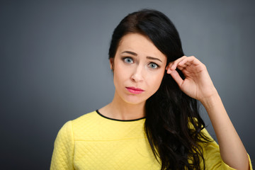 Young emotional beauty woman standing on gray background